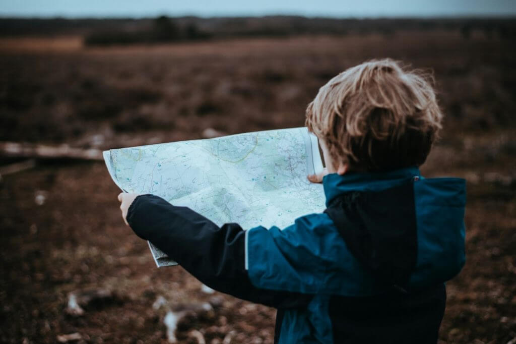Child holding a map in nature